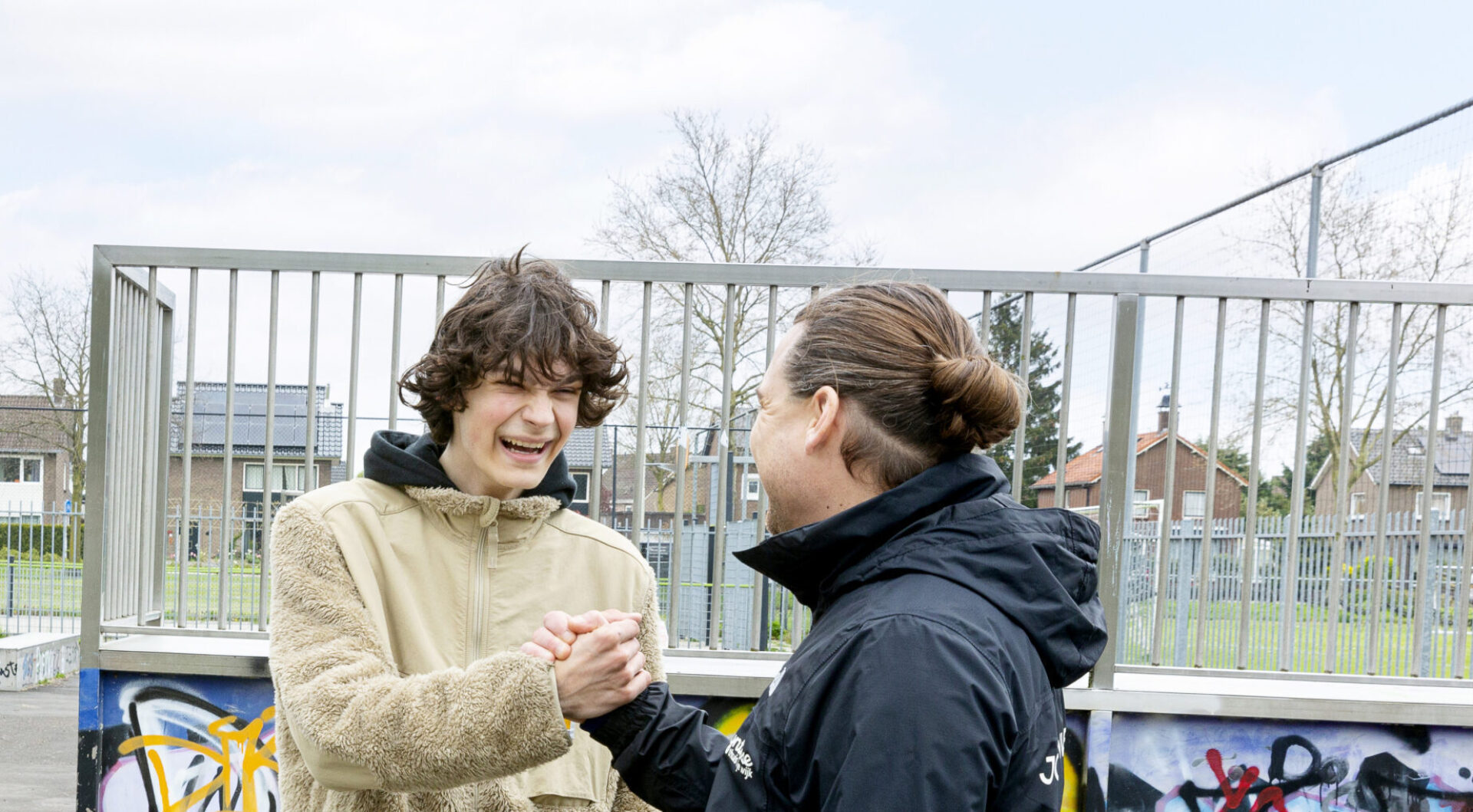 Foto jongerenwerker Synthese met jongere op skatebaan